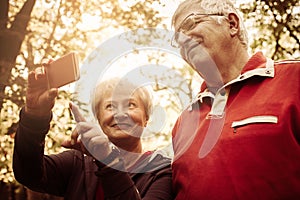 Seniors couple in sports clothing taking self picture in p