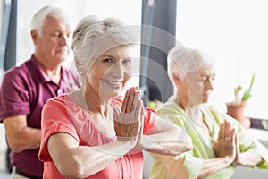 Seniors doing yoga with closed eyes