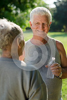 Seniors drinking water after fitness in park