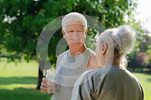 Seniors drinking water after fitness in park