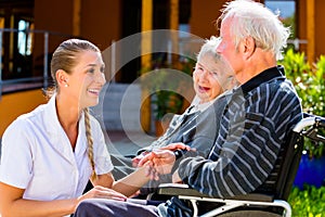 Seniors eating candy in garden of nursing home