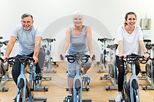 Seniors on exercise bikes in spinning class at gym