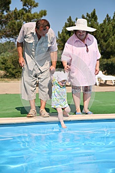 Seniors with girl near a pool