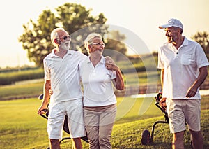 Seniors golfers talking and walking