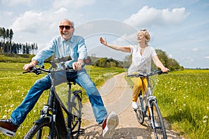 Seniors having fun on bicycles in spring