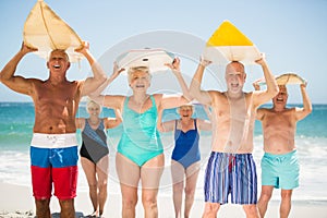 Seniors holding surfboards at the beach