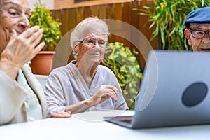 Seniors learning how to use a laptop in a geriatric