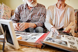 Seniors looking at their photo album at home