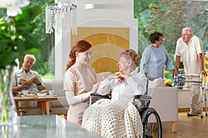 Seniors in a luxury living room of a private retirement home. Te photo