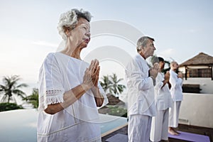 Seniors practising yoga outdoors together