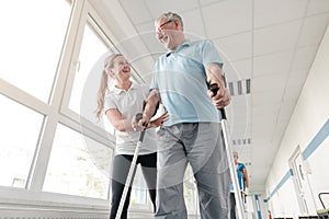 Seniors in rehabilitation learning how to walk with crutches