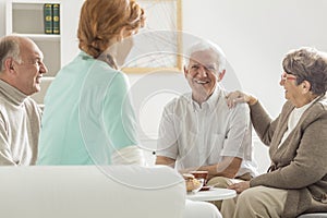 Seniors sitting with nurse