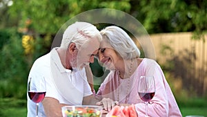 Seniors sitting at table and remembering their life together, happy marriage