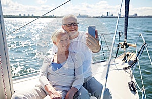 Seniors with smartphone taking selfie on yacht