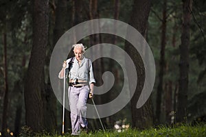 Seniors Sports and Healthy Lifestyle Concepts. Mature Caucasian Woman Having Fitness Nordic Walking Exercise with Backpack in Deep