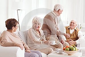 Seniors talking and drinking coffee