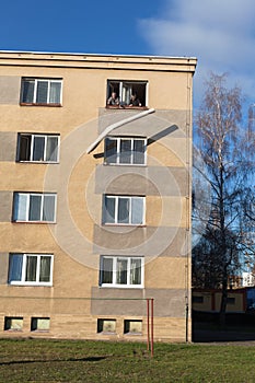 Seniors throwing rolled carpet out of a window of a building