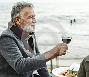 Seniors toasting with red wine at the beach