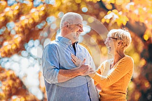 Seniors on a walk in autumn forest