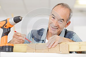 senir man doing woodwork