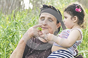 Senor Grandmother with her grandchild at garlic garden photo