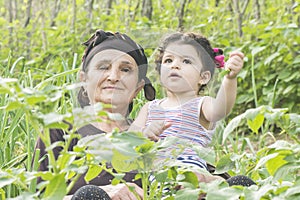 Senor Grandmother portrait with her grandchild at garden enjoying together photo