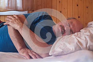 Senor man sleeping on bed at home. Close up. photo