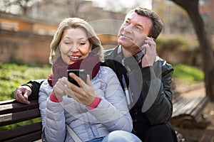 Senor man and woman with mobile phones