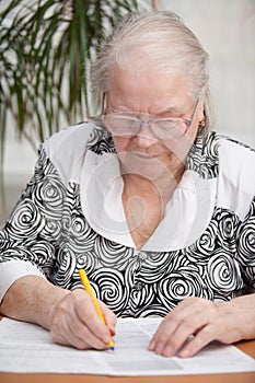 Senor woman signing document