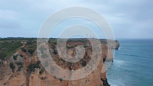 Sensational aerial drone view flying above Lagos Portugal coastline, cloudy day, flying forward