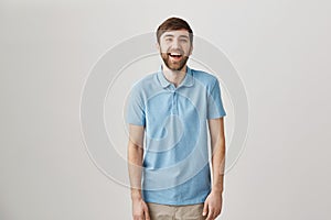 Sense of humour makes man unique. Portrait of slender ordinary caucasian guy with beard and moustache laughing and