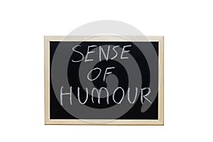 SENSE OF HUMOUR written with white chalk on blackboard