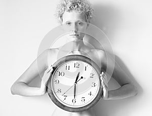 Sensitive curly girl with big clock in hands.