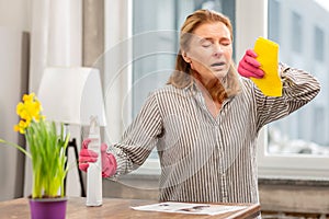 Housewife wearing gloves having sensitivity to cleaning detergents photo