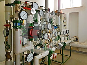 Sensors and devices indicating the parameters of hot water in the heating system of a large house. Interlacing of pipes. Technical