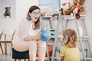 A sensory game with a blue ball played by a professional child t