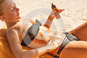 Sensous slim woman applying suntan oil