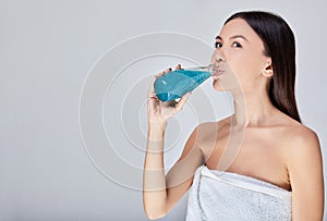 Sensual Asian woman drinks detox cocktail after spa treatments