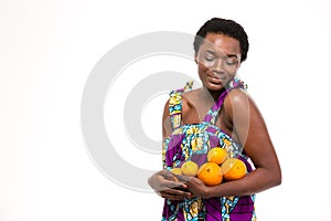 Sensual attractive african woman in bright sundress holding citrus fruits