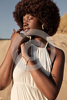 Sensual black woman in white dress in countryside