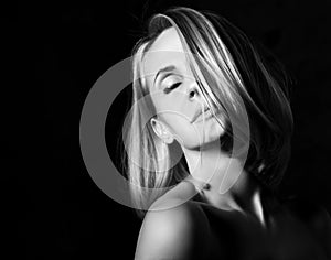 Sensual blonde beautiful woman mysteriously thinking. Black and white image close up portrait