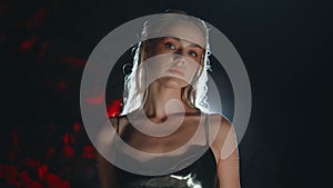 Sensual blonde posing dark background closeup. Fabulous model in party light