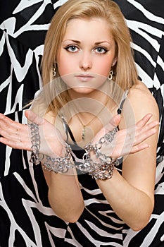 Sensual blonde stretches out her hands in chains