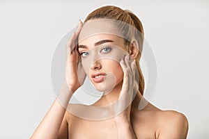 Sensual Blonde Woman Posing Touching Perfect Face Over Gray Background
