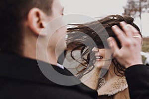 Sensual bride with windy hair and groom embracing on road. happy couple hugging  and kissing in wind, romantic tender and sexual