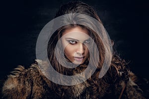 Sensual brunette female dressed in a fur coat.