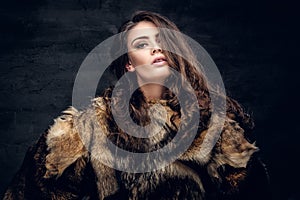 Sensual brunette female dressed in a fur coat.