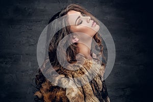 Sensual brunette female dressed in a fur coat.