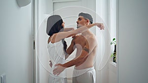 Sensual couple embracing cozy home hall. Half naked man cuddling cute woman