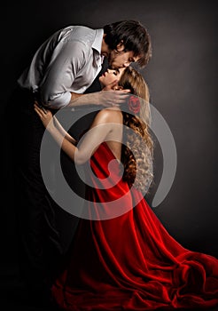 Sensual Couple Kissing in Love. Handsome Man hugging romantic Woman in red Dress. Valentines People Concept photo